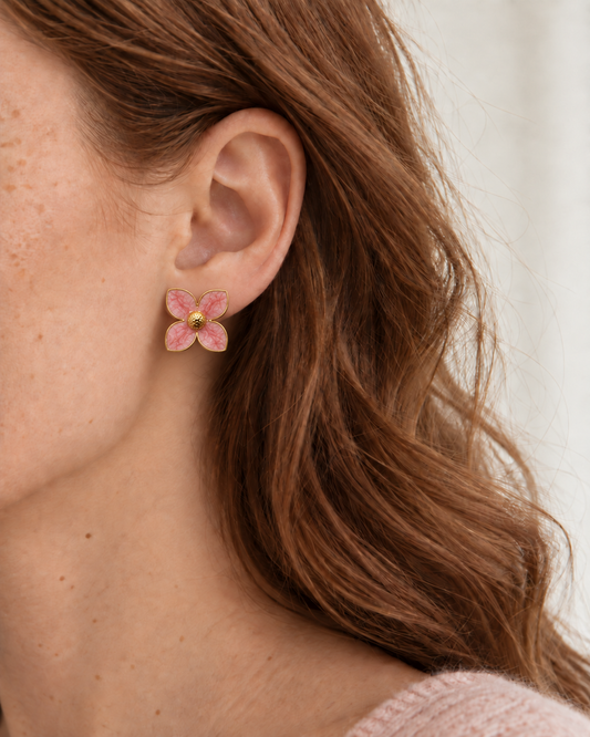 Felicia – blomformade örhängen med rosa kronblad och guldfärgade kanter, burna på modell. ISOLDE ACCESSORIES.
