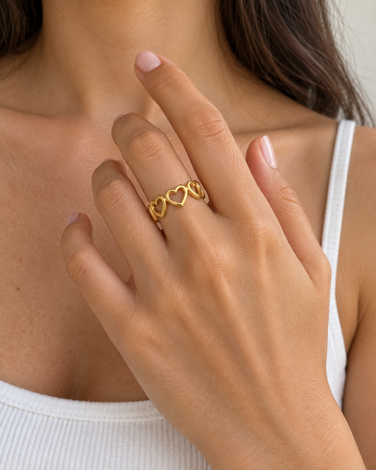 Agnes från ISOLDE ACCESSORIES – guldfärgad öppen ring med hjärtmotiv, buren på modell.